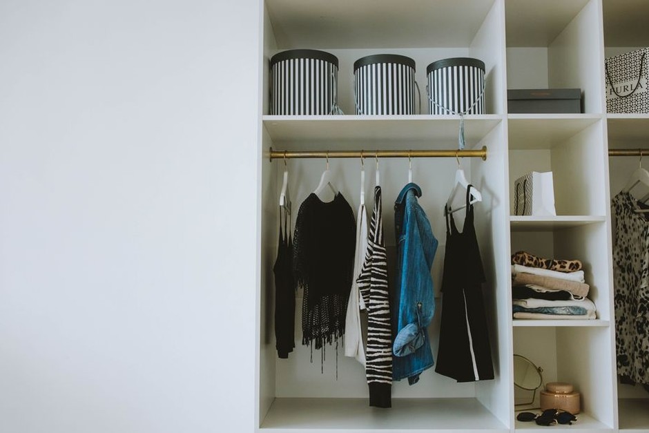 Open wardrobe with neatly arranged clothes and shelves